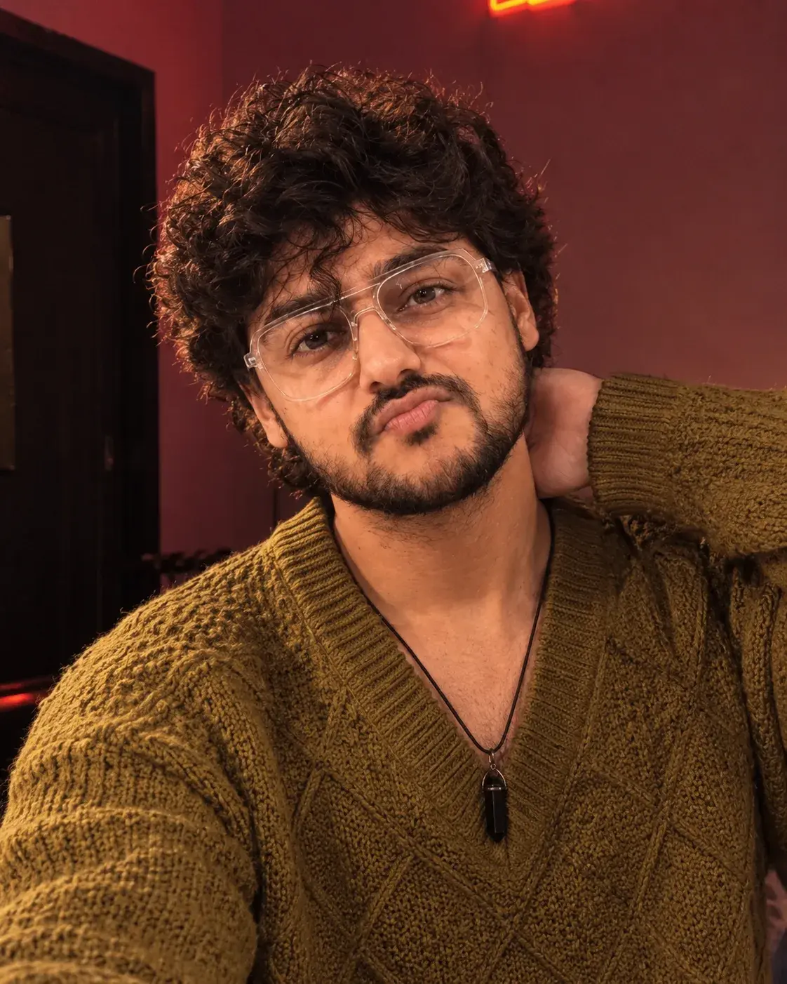 A Boy With Messy Hair Wear V Neck Olive Mustard Color Sweater In A Playful Action.