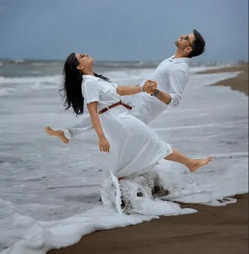 A Romantic Cinematic Beach Portrait Of A Couple In White Linen Outfits