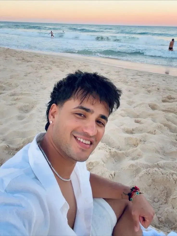 A Young Man Sitting On The Beach