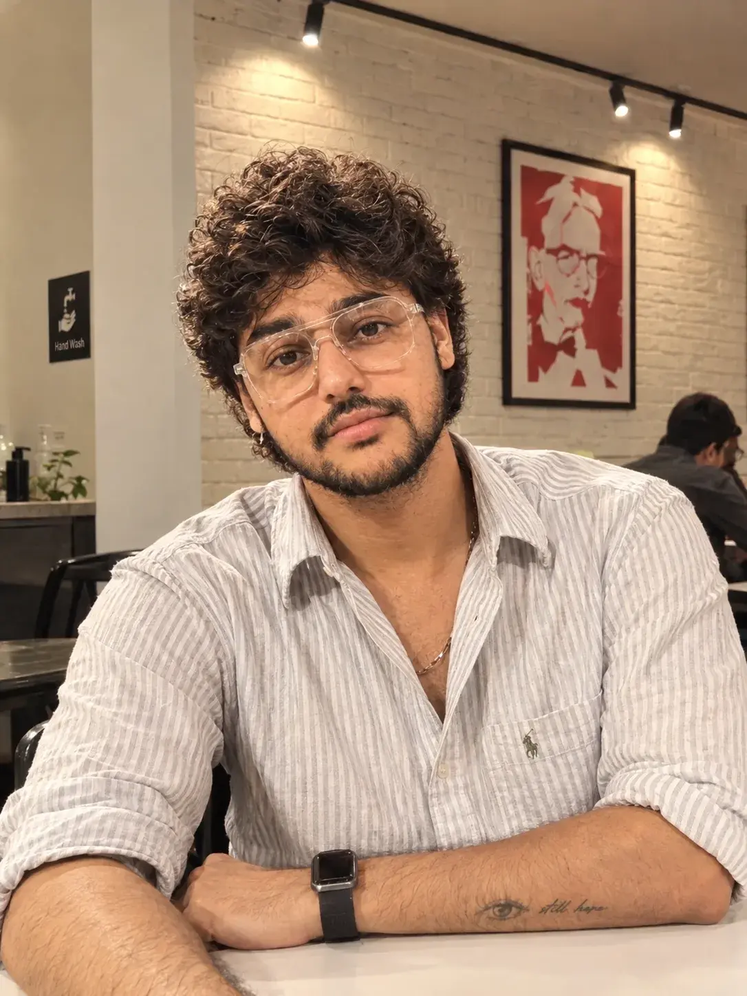 A Young Man Wears A Light Grey And White Vertical-Striped Button Up Shirt
