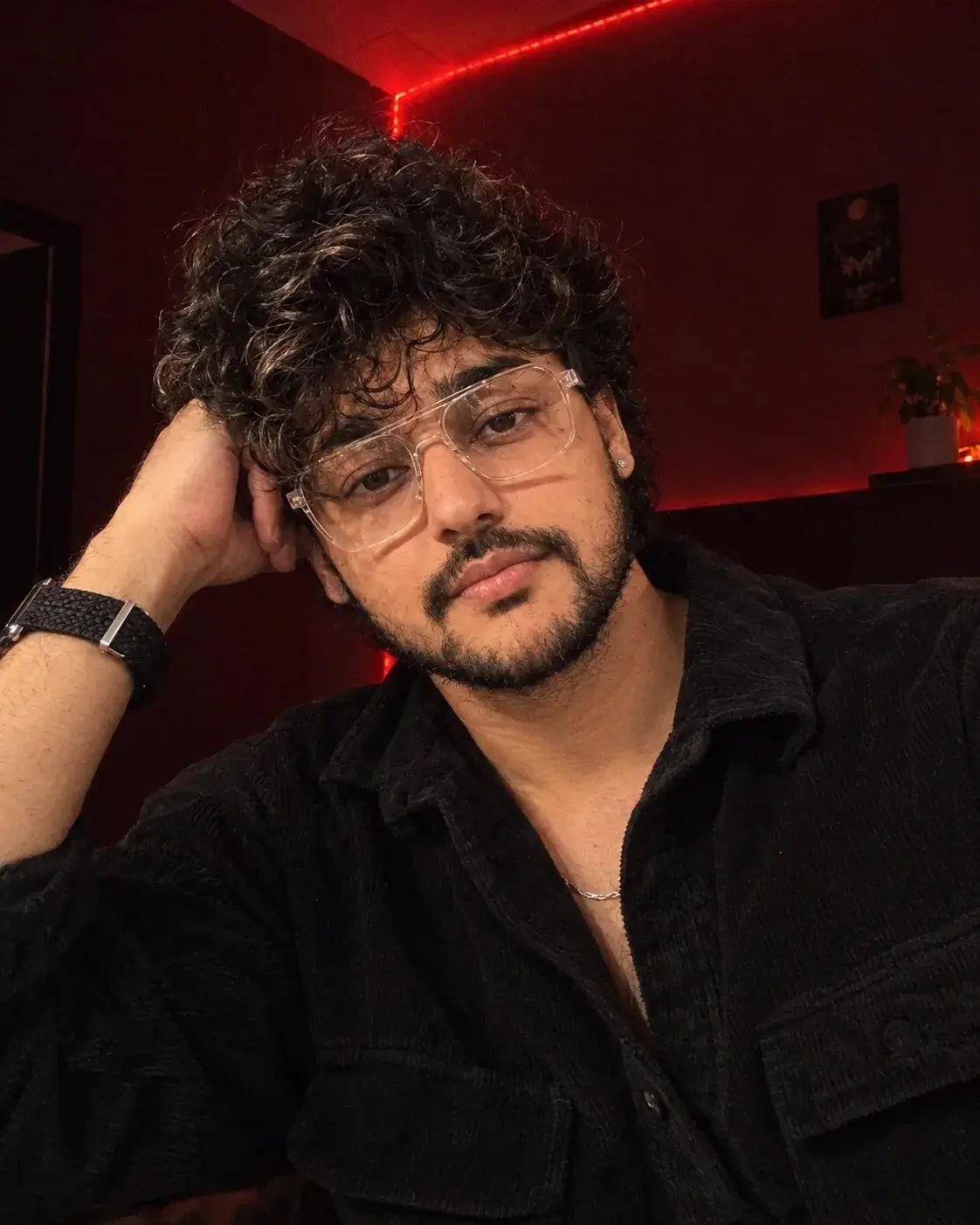 A Young Man With Dimly Lit Room With Moody Red LED Strip Lighting