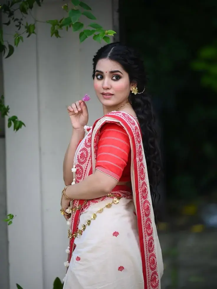 Candid Bengali Festive Portrait Of Young Woman In Lal Paar Saree Holding Bougainvillea Flower