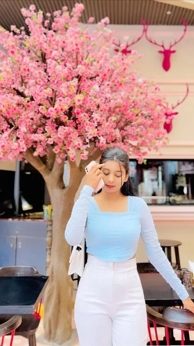 Candid Café Portrait Of Young Woman By Pink Cherry Blossom Tree