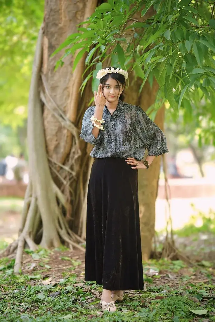 Candid Full-Length Botanical Garden Portrait Of Young South Asian Woman In Floral Blouse And Velvet Skirt With Jasmine C