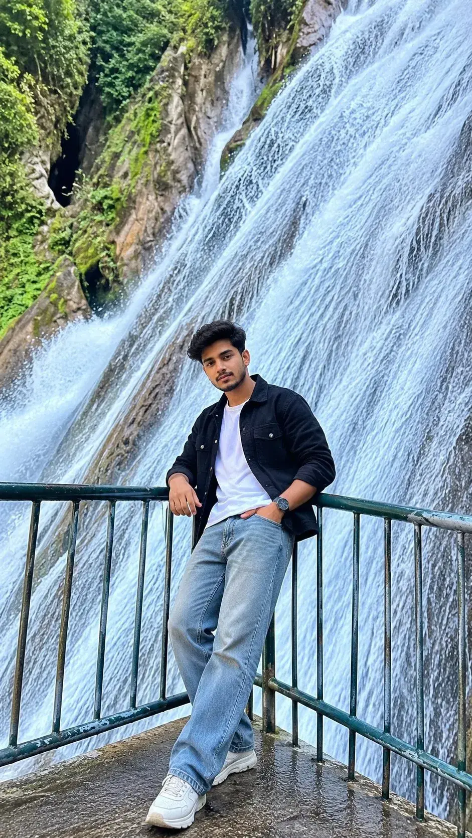 Candid Full-Length Outdoor Portrait Of Young Indian Man Leaning By Waterfall Railing