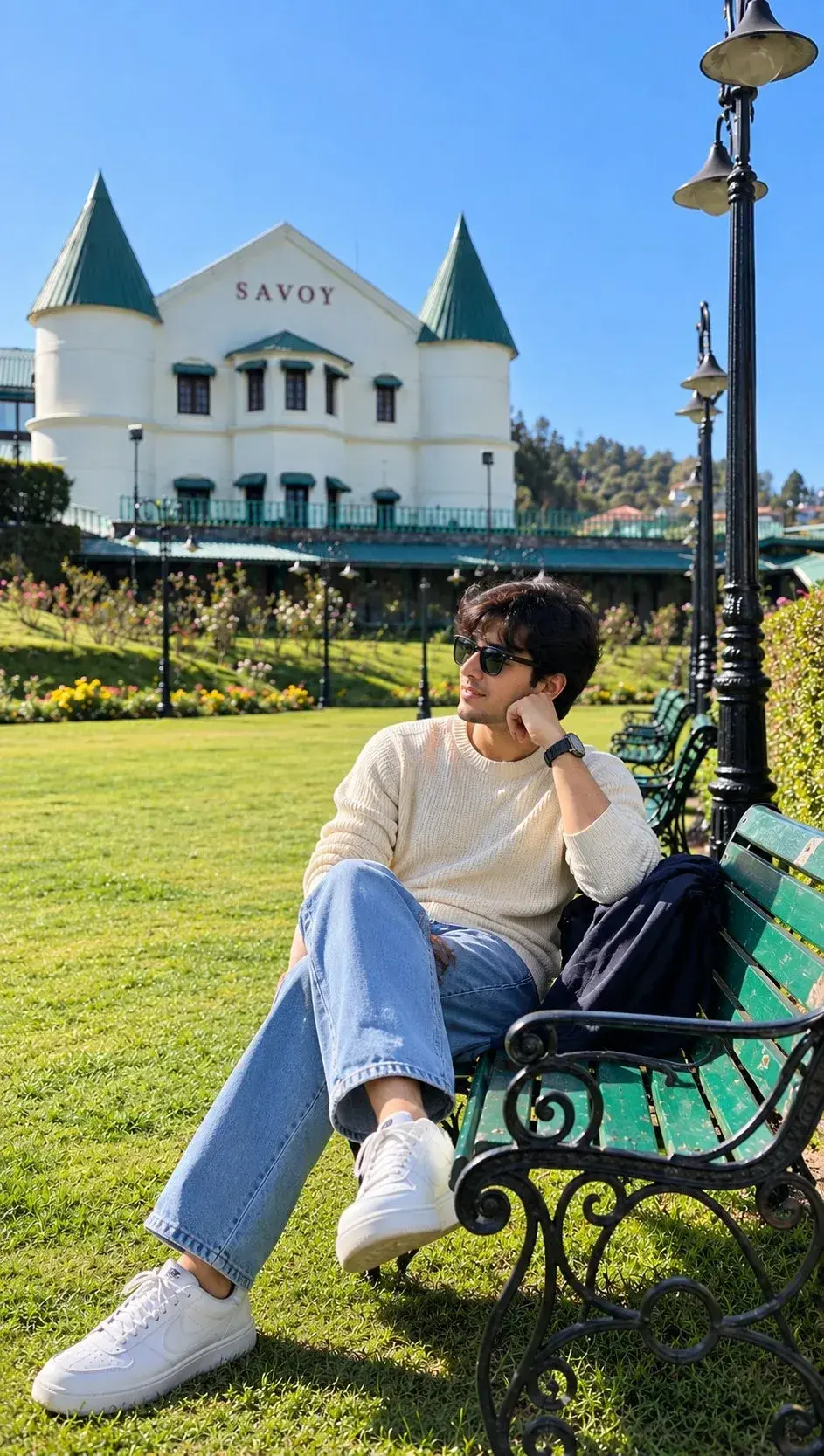 Candid Full-Length Outdoor Portrait Of Young Indian Man On Park Bench By Historic Savoy Hotel