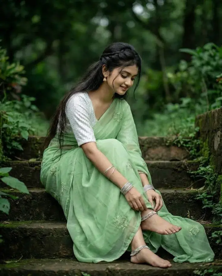 Candid Full-Length Outdoor Portrait Of Young Indian Woman In Mint Green Saree On Stone Steps