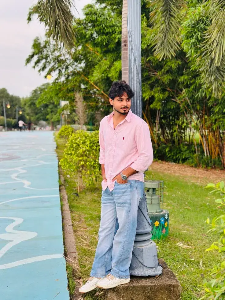 Candid Full-Length Outdoor Portrait Of Young Man Leaning On Lamp Post