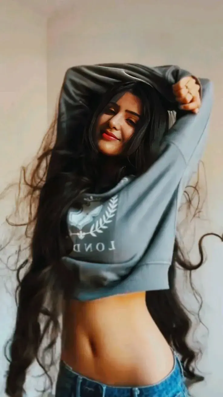 Candid Indoor Portrait Of Young Woman Stretching In Cropped Sweatshirt