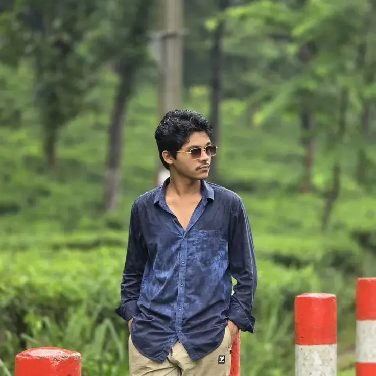Candid Lush Tea Garden Roadside Portrait Of Pensive Young South Asian Man With Sunglasses In Tie-Dye Indigo Shirt