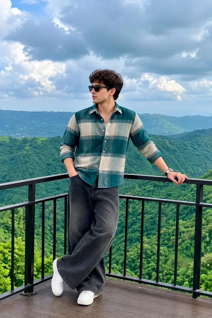 Candid Mountain Balcony Portrait Of Handsome Young South Asian Man In Teal Plaid Shirt Leaning On Metal Railing