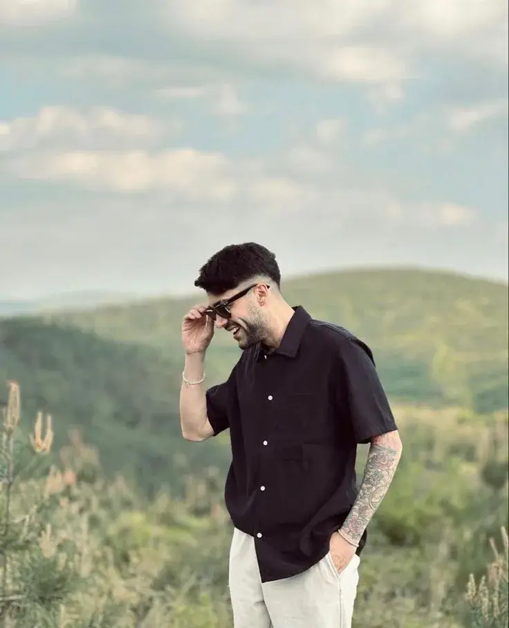 Candid Outdoor Mountain View Portrait Of Young Man Adjusting Sunglasses
