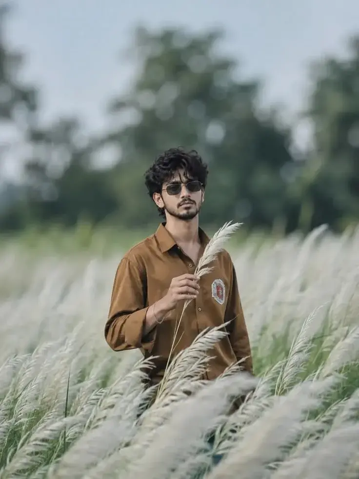 Candid Outdoor Portrait Of Young Indian Man Holding Kash Grass Reed