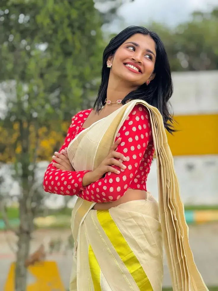 Candid Outdoor Waist-Up Portrait Of Smiling Indian Woman In Traditional Kasavu Saree