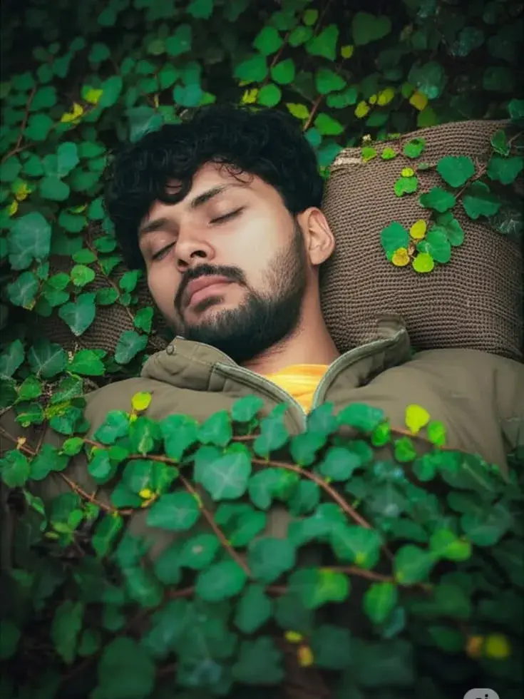 Candid Overhead Close-Up Portrait Of Young South Asian Man Sleeping On Knit Cushion Immersed In Dense Green Creeping Fig