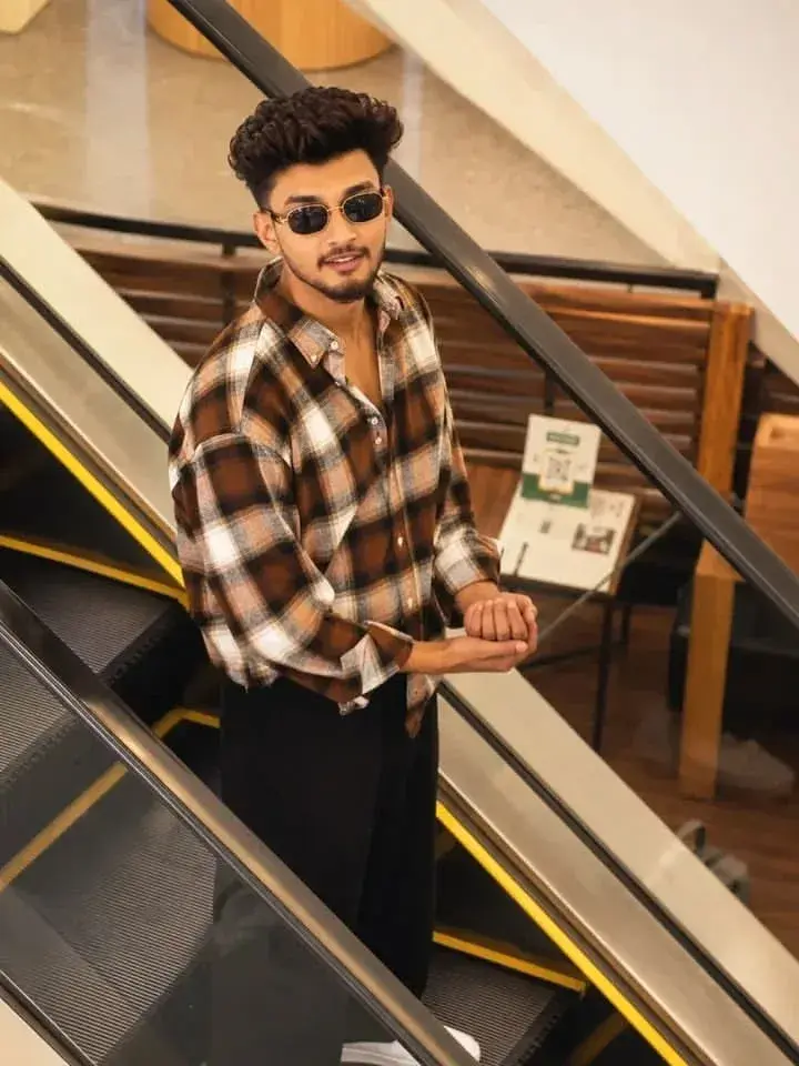 Candid Portrait Of Young South Asian Man In Plaid Flannel On Mall Escalator