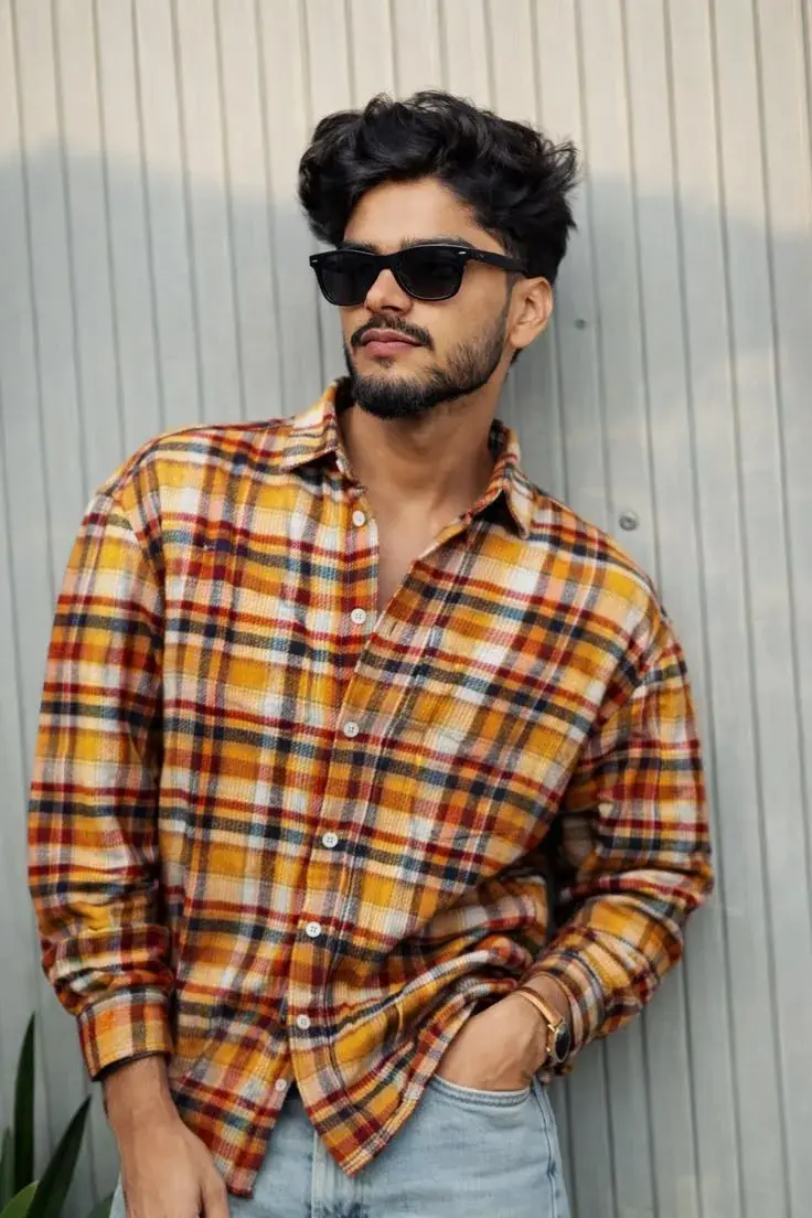 Candid Street Style Portrait Of Young South Asian Man In Yellow And Orange Plaid Flannel Shirt And Wayfarer Sunglasses L