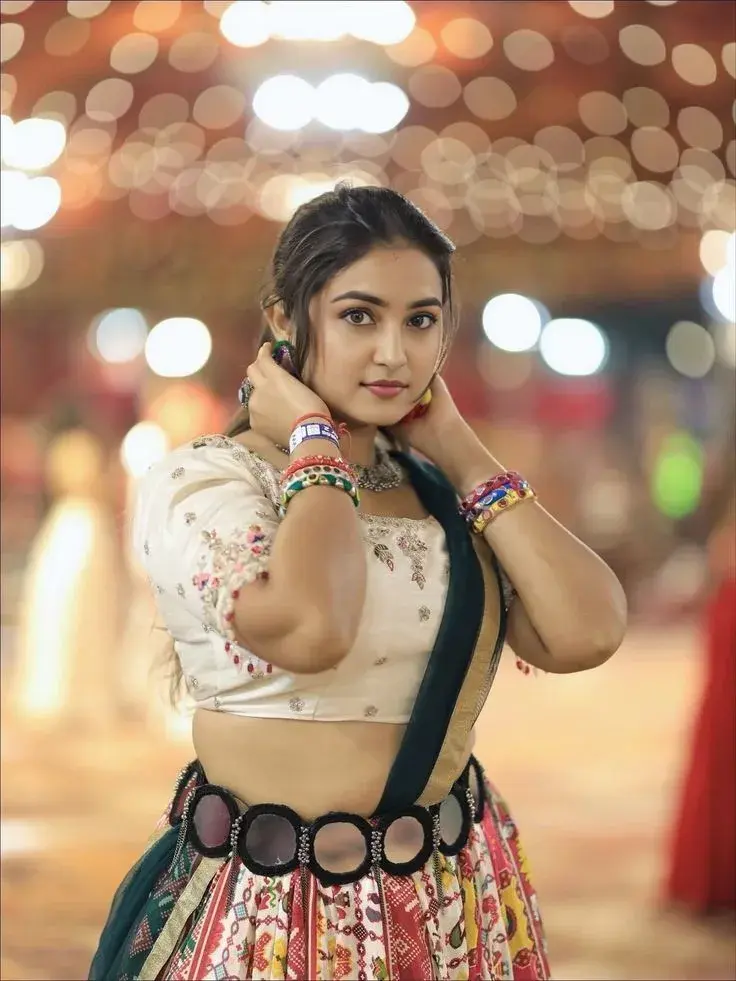 Candid Sunlit Festive Night Portrait Of Smiling Young South Asian Woman In Embroidered White Choli And Mirror-Work Garba