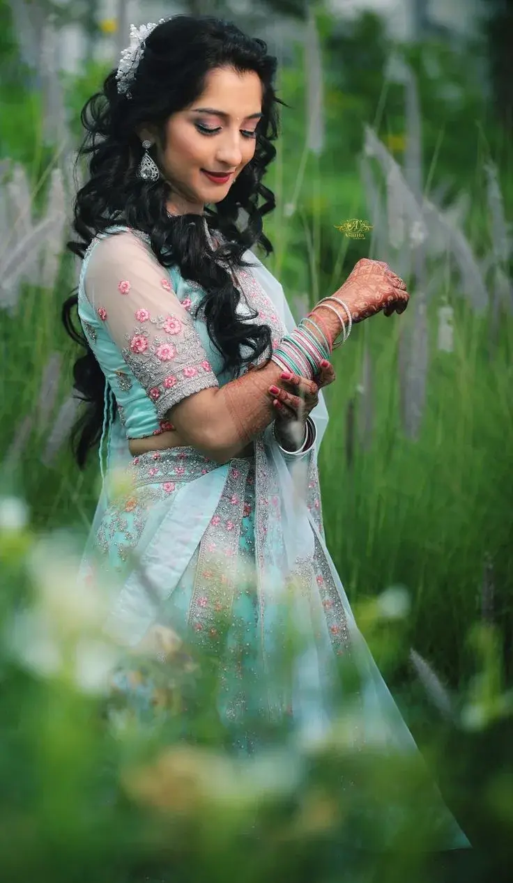 Candid Sunlit Garden Portrait Of Young South Asian Bride In Pastel Mint Lehenga Adjusting Bangle Stack