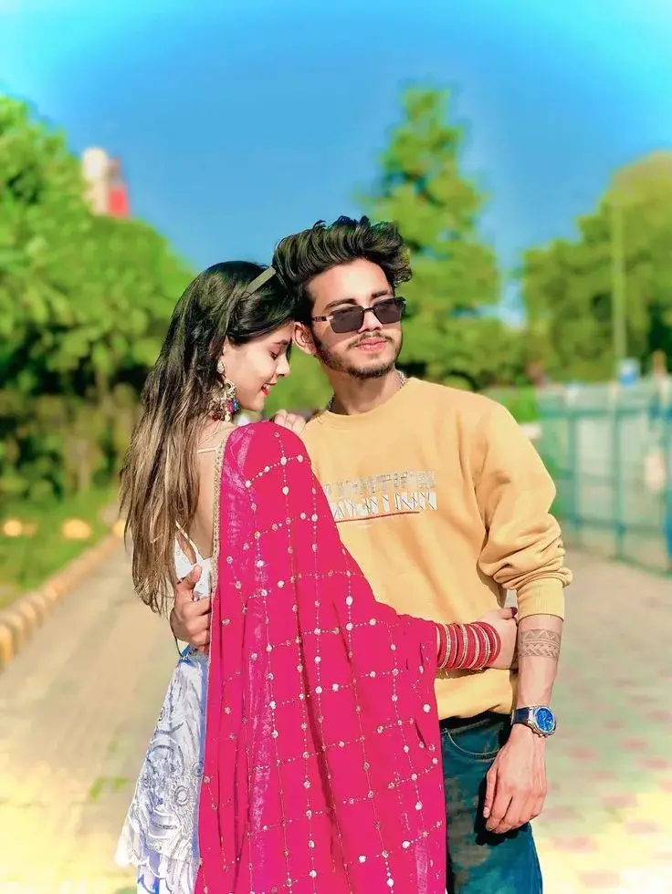 Candid Sunlit Garden Promenade Portrait Of Affectionate Young South Asian Couple In Yellow Sweatshirt And Fuchsia Embroi