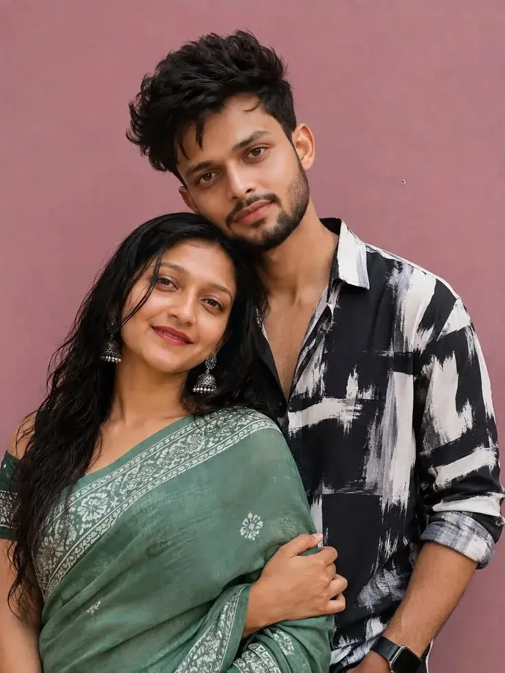 Candid Sunlit Studio Portrait Of Young South Asian Couple In Sage Green Saree And Abstract Brushstroke Shirt Against Ros