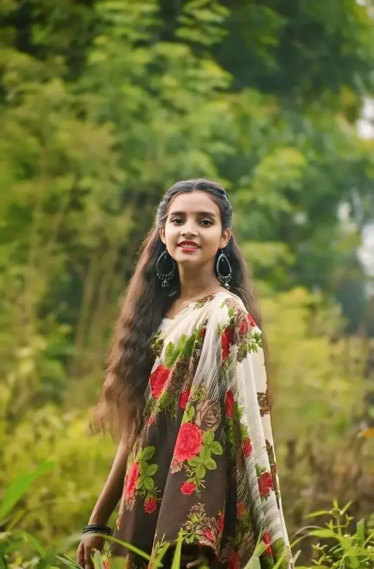 Candid Waist-Up Outdoor Portrait Of Young Indian Woman In Floral Saree Amidst Nature