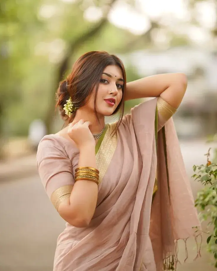 Candid Woman In Muted Rose Linen Saree With Jasmine Hair Bun In Outdoor Garden