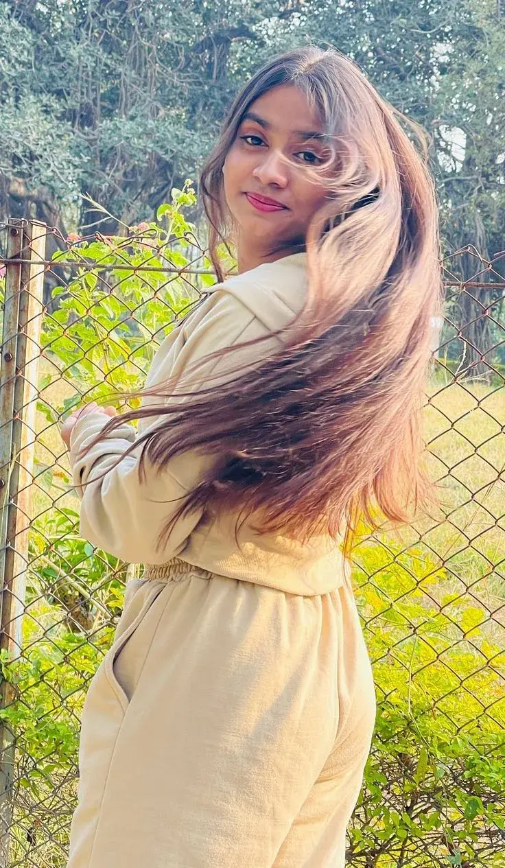 Candid Young Woman In Beige Loungewear Set With Windblown Hair In Golden Sunlight