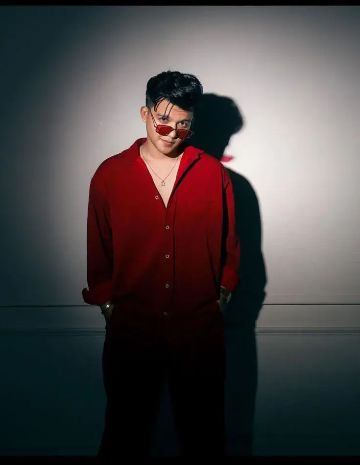 Dramatic Spotlight Studio Portrait Of Stylish Young South Asian Man In Deep Red Shirt And Red Tinted Sunglasses