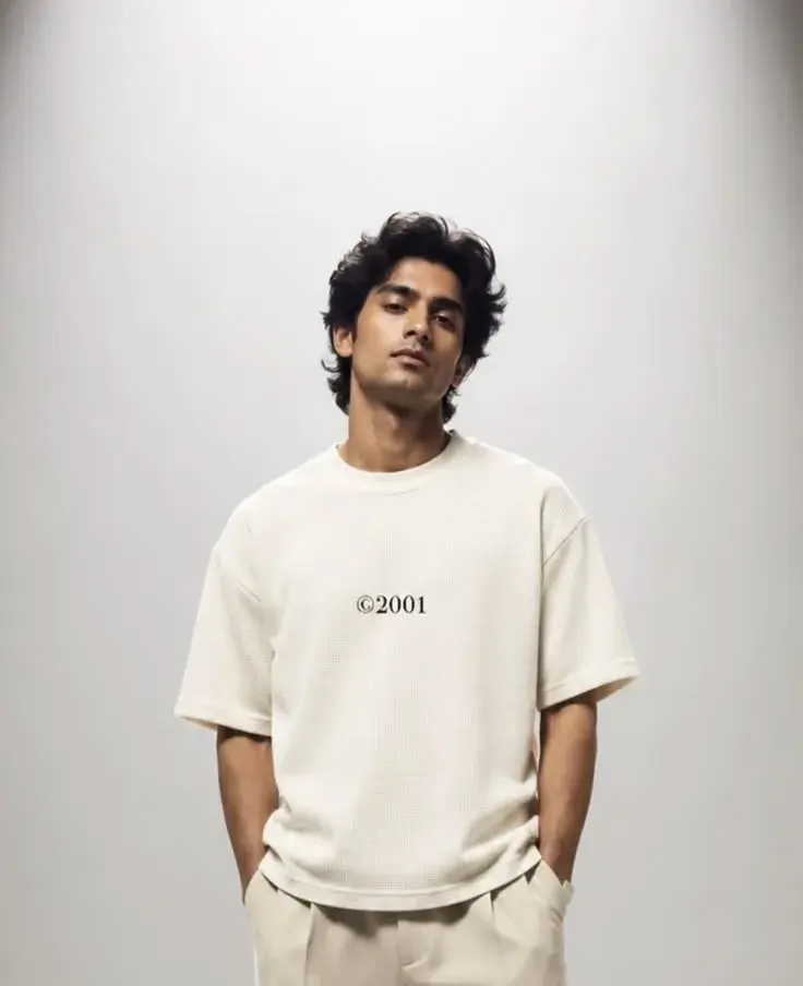 Dramatic Studio Overhead Spotlight Portrait Of Young South Asian Man In Off-White Waffle T-Shirt