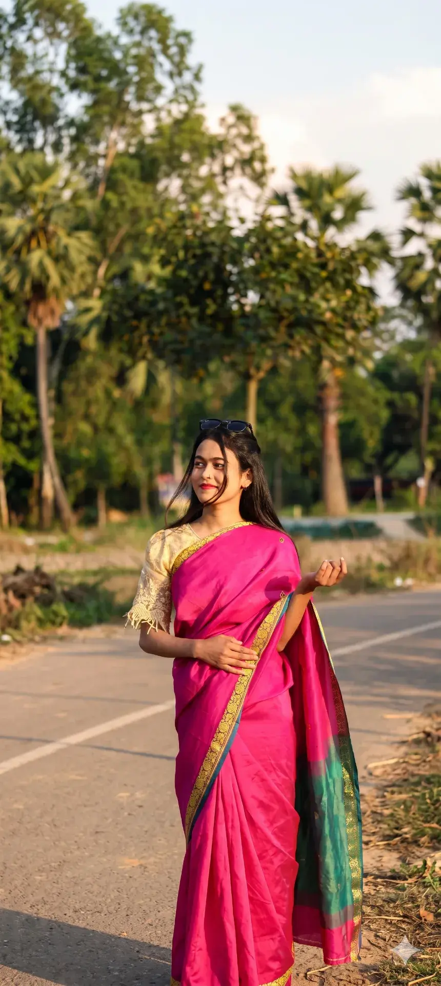 Golden Hour Rural Promenade: Young Woman In Vibrant Rani Pink Silk Saree