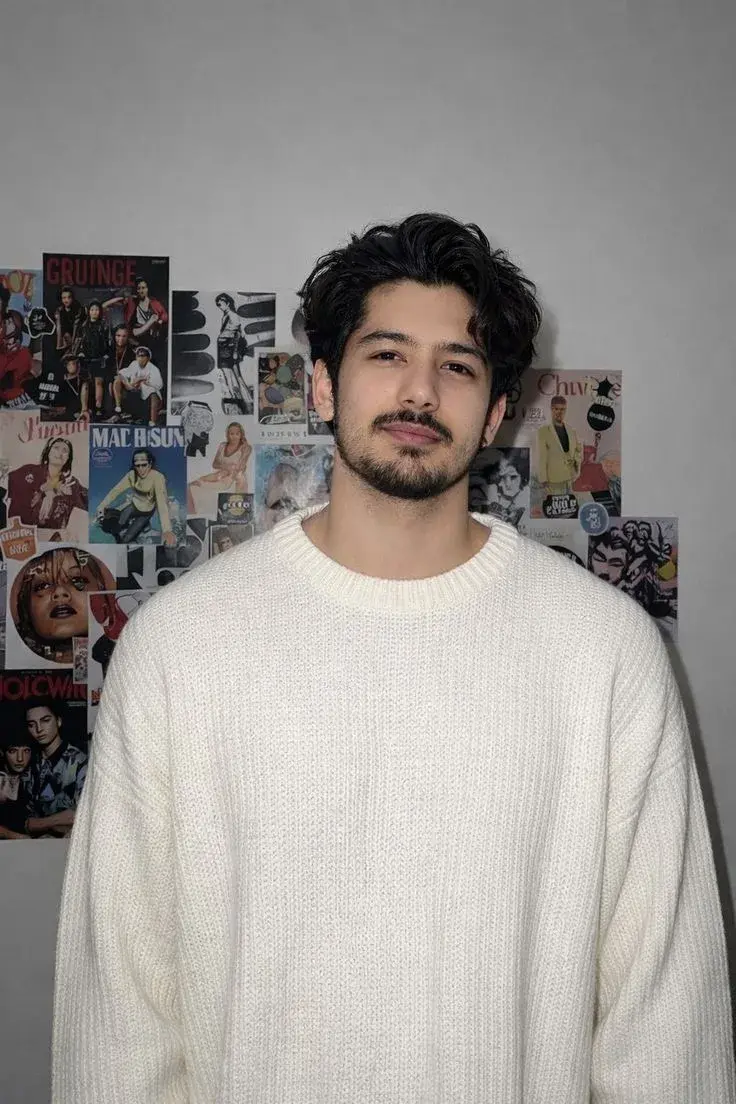 Indoor Portrait Of Young Indian Man In Oversized Cream Knit Sweater