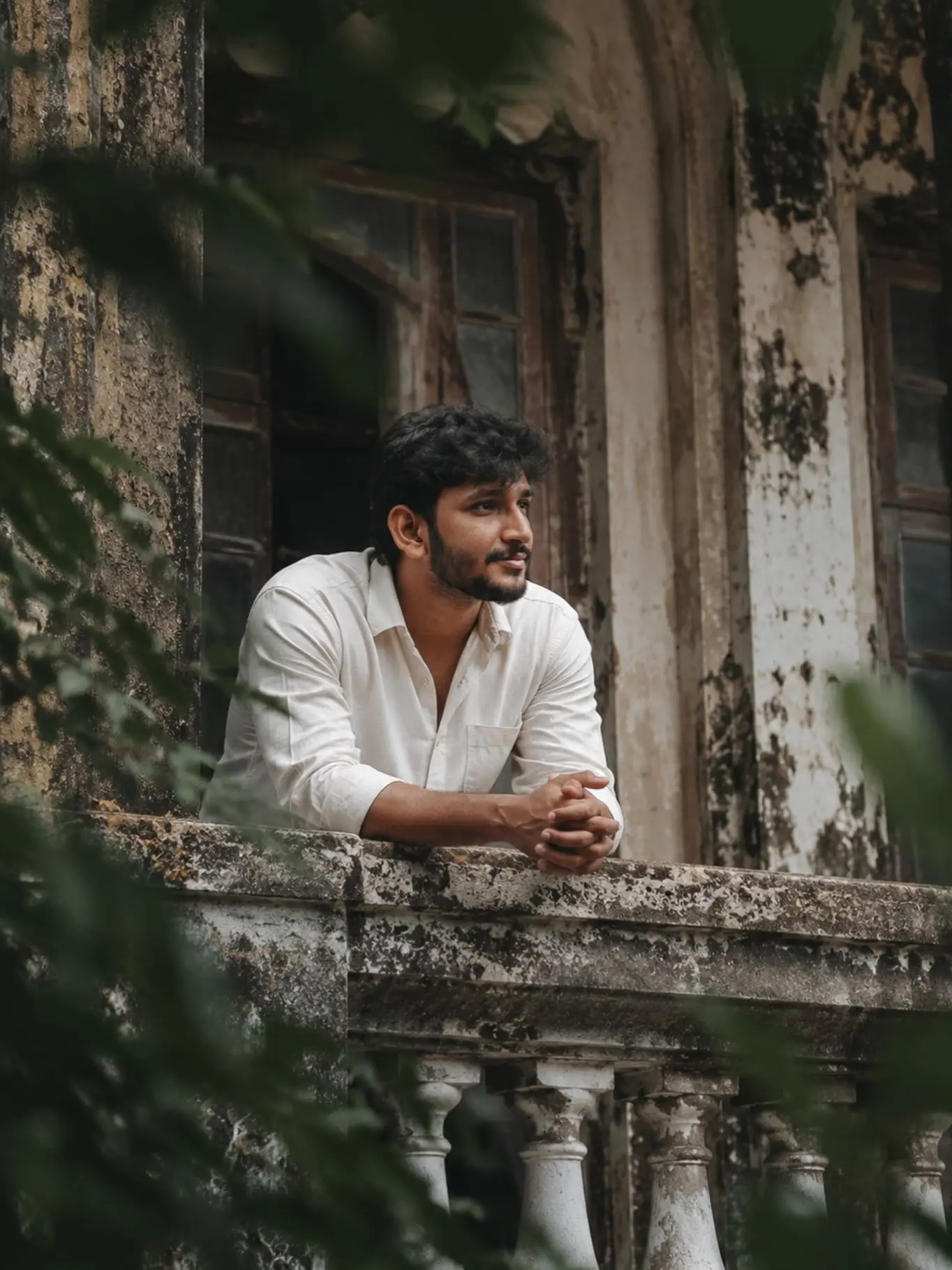 Man Leaning On Old Rustic Stone Balcony Looking Away