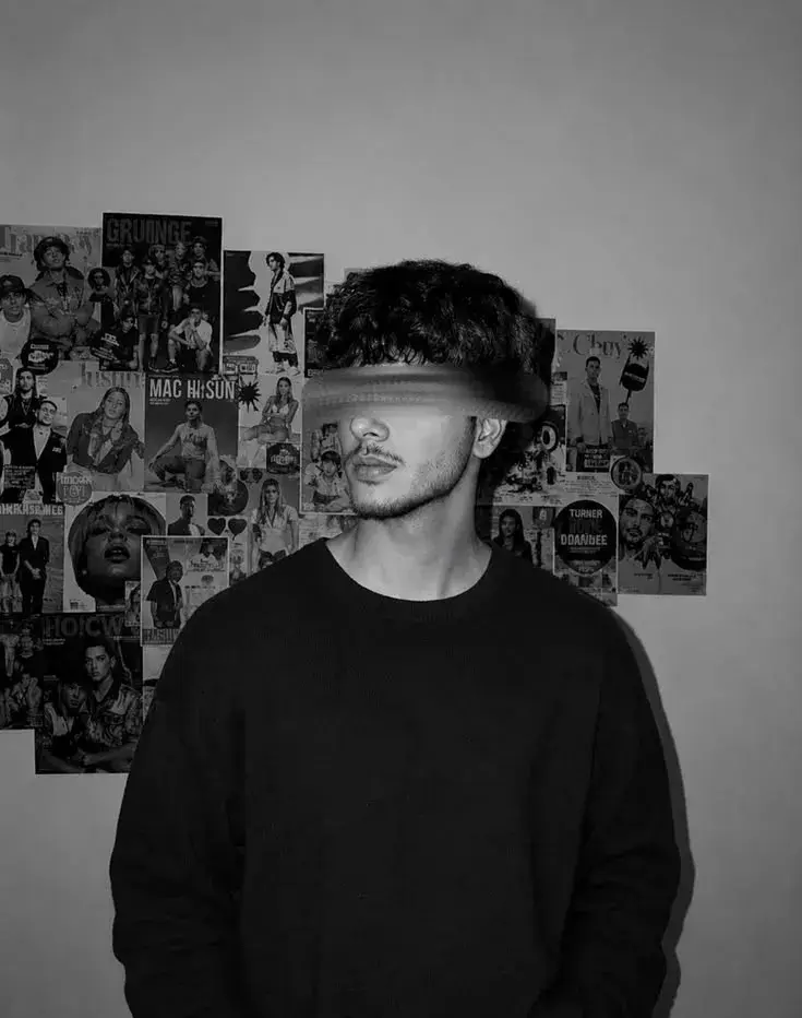 Monochrome Waist-Up Portrait Of Young Man With Motion-Blurred Eyes And Poster Wall