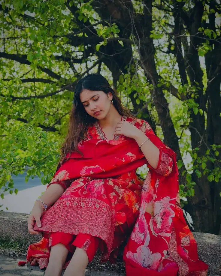 Outdoor Portrait Of Indian Woman In Red Floral Salwar Suit Under Trees